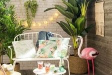 19 a mini tropical deck with potted greenery, a pink flamingo, colorful candle lanterns, elegant white forged furniture and lights