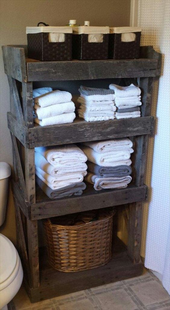 a large pallet storage piece with several shelves, a basket for storing laundry and some cubbies on top