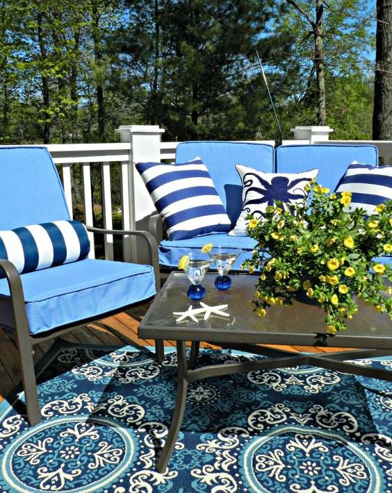 colorful pillows in blue and white for a nautical feel and star fish on the table plus a matching rug