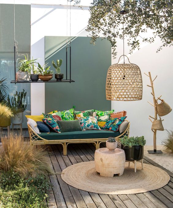 sân thượng nhiệt đới chào đón với ghế sofa rttan, gối đầy màu sắc, thảm đay, giỏ đan bằng liễu gai và chao đèn bằng liễu gai cộng với chậu cây sân thượng nhiệt đới chào đón với ghế sofa rttan, gối đầy màu sắc, thảm đay, giỏ đan bằng liễu gai và chao đèn bằng liễu gai cộng với chậu cây