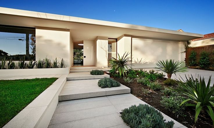 white concrete and stone contrast the greenery and the green lawn that are represented here