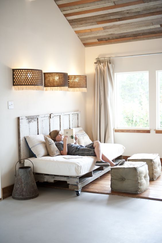 a reading nook fitted with a pallet daybed on casters and a matching headboard brings a shabby chic feel