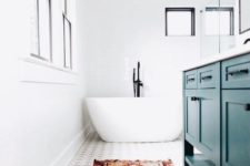 a bright eclectic bathroom done in white and neutrals and accented with a red boho rug and a teal vanity