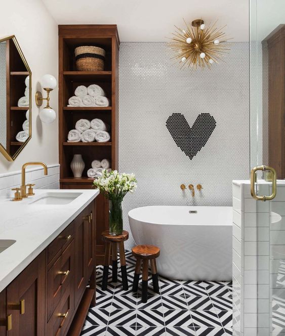 a contemporary meets mid-century odern bathroom in black and white with much rich-colored wood and gilded touches