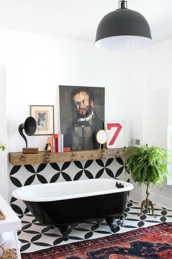 a creative eclectic bathroom with black and white tile, a bold printed rug, a reclaimed wood mantel and some art, greenery in a pot