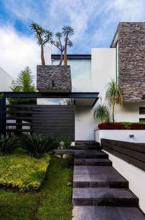 a modern and fresh front yard with stone tiles, with grasses, succulents and some trees inspires and welcomes in
