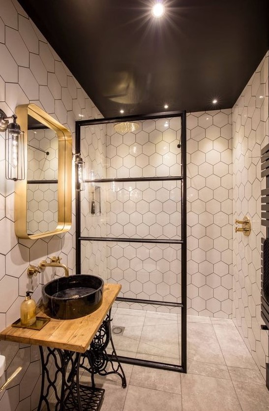 a stunning eclectic bathroom mixing industrial and contemporary bathroom and done in a black, white and gold color scheme