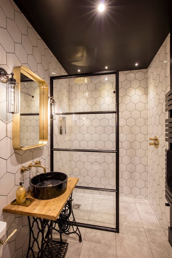 a stunning eclectic bathroom mixing industrial and contemporary bathroom and done in a black, white and gold color scheme