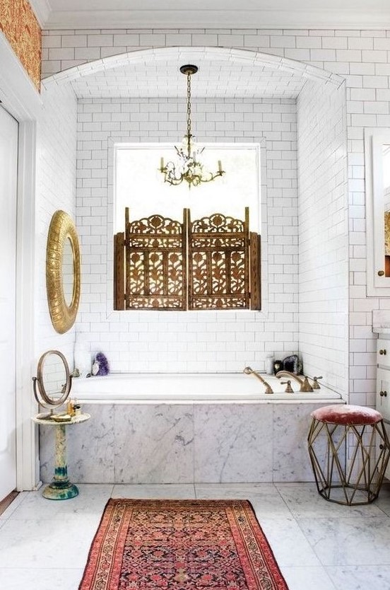 a unique eclectic bathroom with touches of vintage and Moroccan styles, with gilded elements in both styles and a boho rug