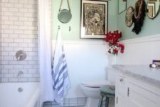 a vintage meets boho chic bathroom, with lots of mirrors and paintings, with a colorful rug and subway tiles
