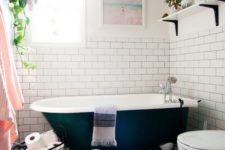 an eclectic bathroom with potted greenery, black and white tiles on the floor and touches of blush