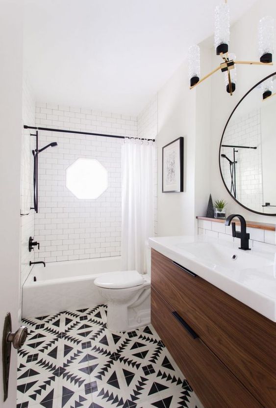 an eclectic vintage meets boho chic bathroom with mosaic tiles, a wooden vanity and black fuxtures