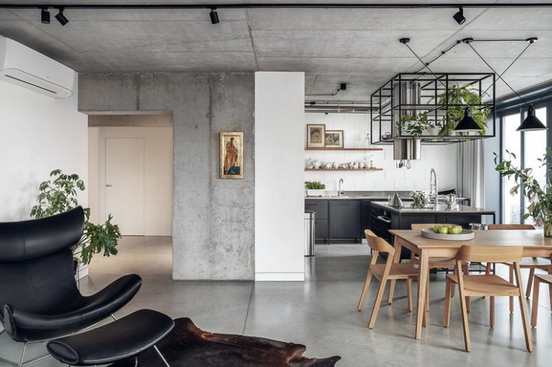 The space features concrete walls and floors, they are softened with animal skins and greenery in pots The space features concrete walls and floors, they are softened with animal skins and greenery in pots