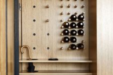 05 The entryway is comfortable and inimalist, with light-colored wood and sleek shelves