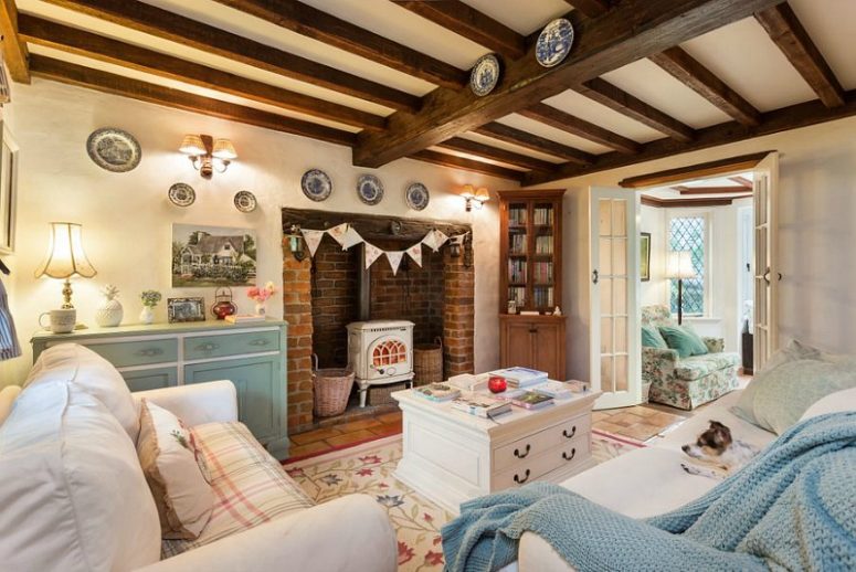 The living room is done with a couple of white sofas, a white coffee table with storage and a light blue dresser, a white hearth in a brick niche The living room is done with a couple of white sofas, a white coffee table with storage and a light blue dresser, a white hearth in a brick niche