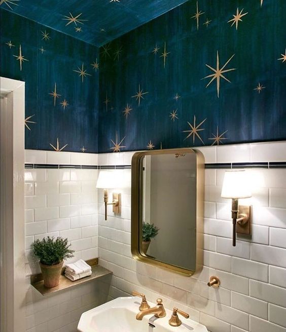 gold fxitures, a gold mirror frame, gold lamps and wall decor with gold stars that matches