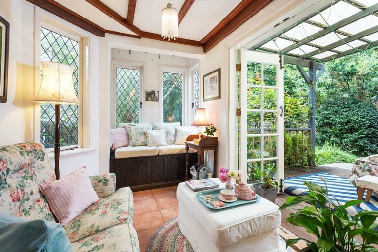 Another living room opens up to the garden, it's done with floral upholstery furniture and lamps and lights Another living room opens up to the garden, it's done with floral upholstery furniture and lamps and lights