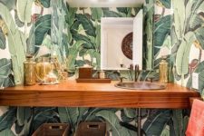 06 a chic powder room done with bright tropical print wallpaper and wooden items