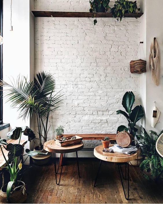 a white brick wall adds texture to this cozy boho chic nook and makes a nce backdrop for greenery and stained furniture