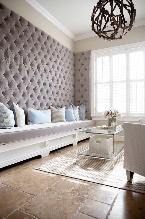 a refined living room with an upholstered taupe wall with a built-in bench brings luxury and coziness