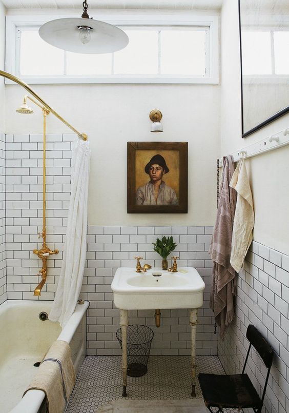 a vintage inspired bathroom with white subway tiles accented with black grout