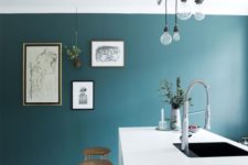 09 highlight a white ultra-minimalist kitchen with a teal accent wall plus a gallery wall on it