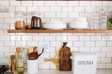 10 a cozy farmhouse kitchen done with white subway tiles with black grout and nautral wooden shelves