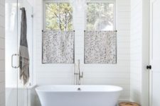 11 a beautiful master bathroom with shiplap walls, ample natural light, and freestanding soaking tub