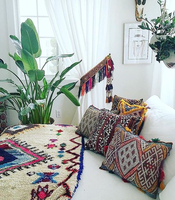 super bold and colorful printed pillows with colorful fringe and a matching curtain holder with tassels for a neutral bedroom