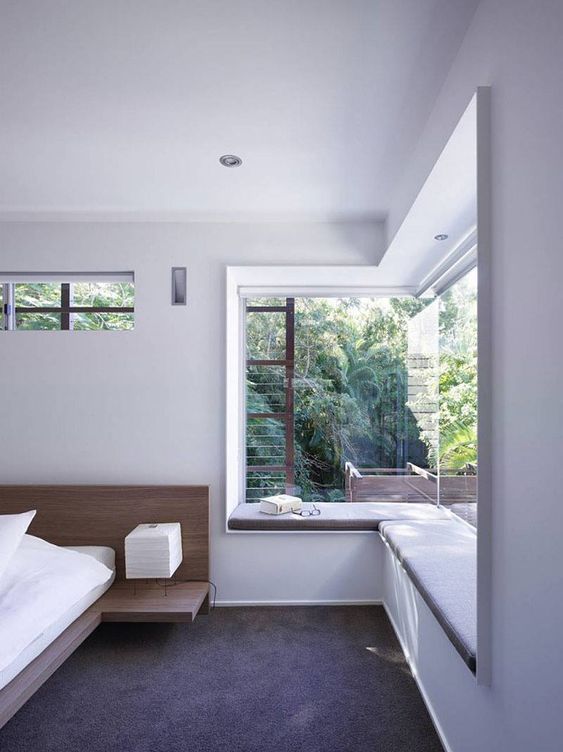 a neutral bedroom that accents the views and a windowsill bench that allows enjoying them even more