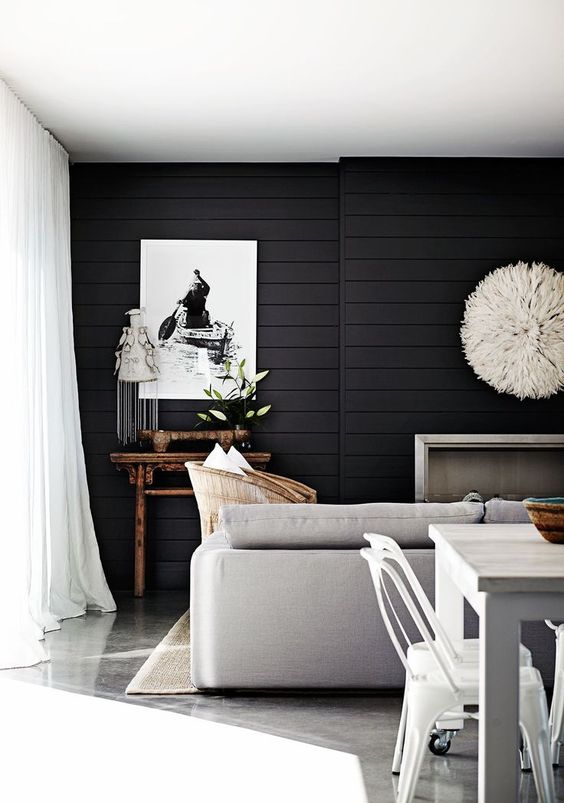 a stylish contemporary living room highlighted with black shiplap on the wall, neutral furniture accents it even more