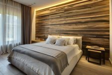 23 a weathered wood clad statement wall with strip lighting on the top gives you light for reading and accents the bed