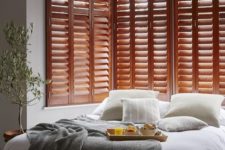 23 rich-stained shutters in the bedroom is a chic decor idea and a great alternative to a bed headboard