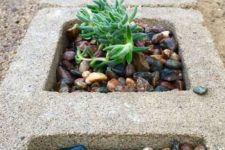 32 sunken cinder blocks used as planters for succulents and pebbles is a bold modern idea