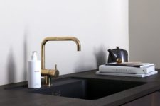 a dark cabinet with an undermount sink and a brass faucet is a chic idea that guarantees a sleek look