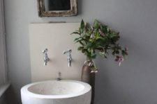 a large white stone vessel sink on a wall-mounted dough wood vanity is a cool rustic item