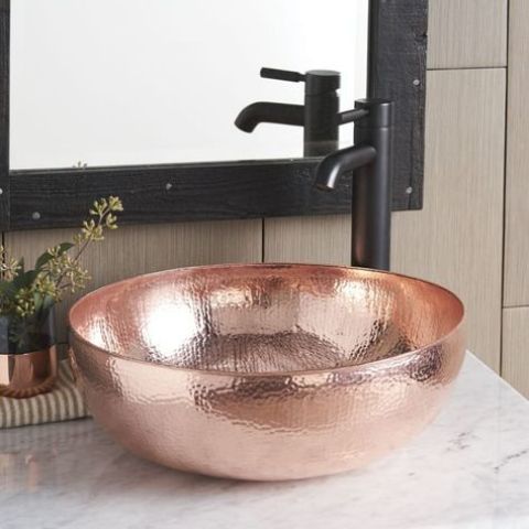 a shiny hammered copper vessel sink with a matte black faucet for a contrast is a stylish and chic idea