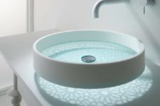 a unique sheer glass bathroom vessel sink with a beautiful painted bottom and light that comes through it