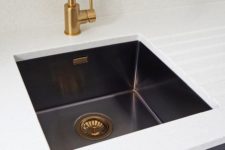 a white and navy vanity with a black undermount sink and brass and copper touches for a refined feel