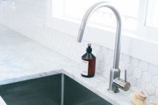 a white stone countertop plus a simple rectangular undermount sink make up a bold and contemporary feel in the space