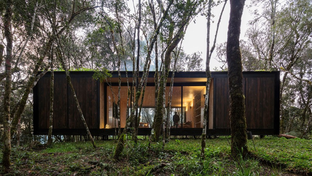 This remote prefab cabin is placed in Brazilian forest and its exterior is done to merge with the surroundings