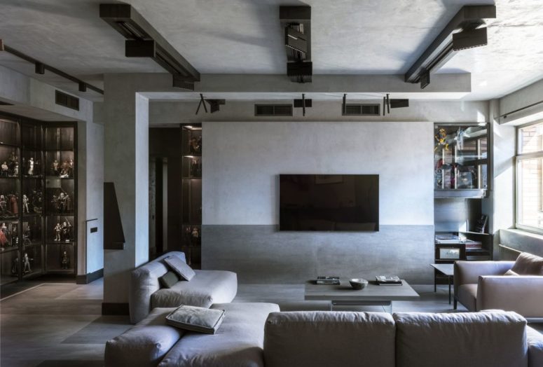 The living room features comfortable furniture, a minimalist coffee table and industrial lights on the ceiling