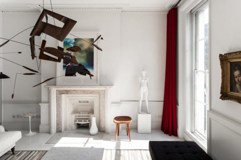 The living room is neutral, the accents are made with artworks, a fantastic chandelier and deep red curtains