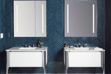 04 a bold contemporary bathroom wih teal skinny tiles clad in a chevron pattern and contrasting white vanities