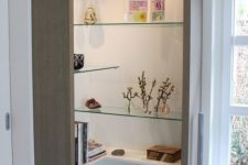 05 an open box shelving unit with sleek white and glass shelves located chaotically and with lights