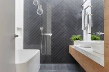 06 a contemporary bathroom clad with long and skinny graphite grey tiles in a chevron pattern