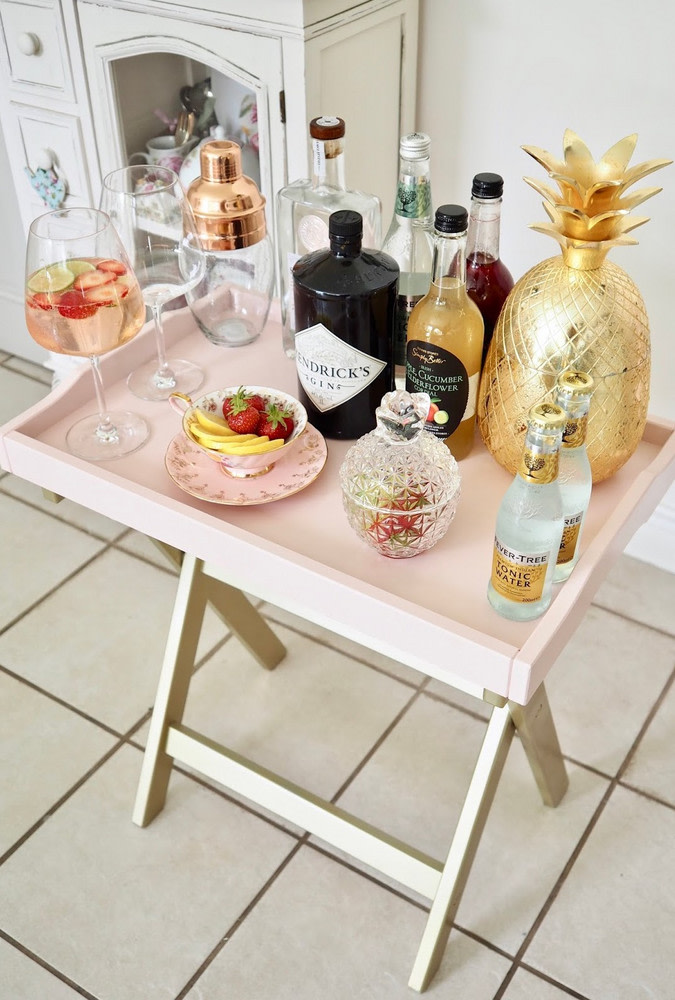 a genius IKEA hack to transform a tray table into an ultra-chic mini bar in blush is a very cute idea