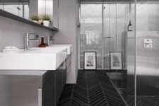 07 a minimalist bathroom with grey walls and a grey vnaity plus a catchy black skinny tile floor for a contrast