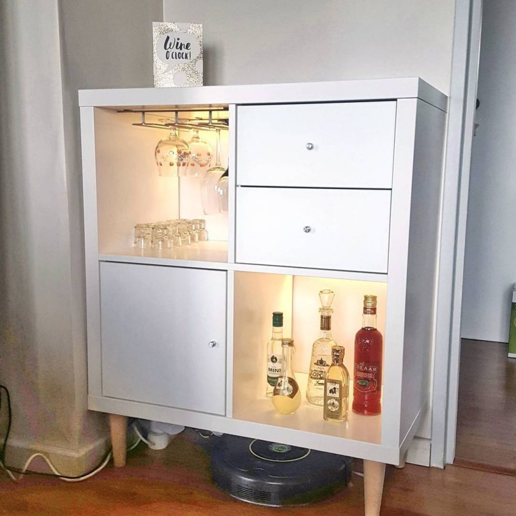 a small home bar with open and closed storage compartments with inner lights from an IKEA Kallax shelving unit