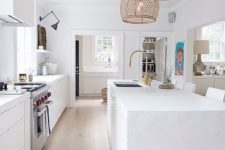 08 a pure white kitchen is given a rustic and outdoor feel with rattan lampshades over the kitchen island